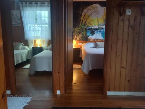 セデイラにあるLa cabañaのベッドが2つあり、壁に絵が飾られた寝室