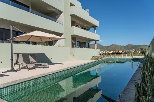 a swimming pool with an umbrella next to a building at The Point At Cerritos # 4 in San Carlos