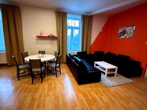 Una sala de estar con un sofá negro y una mesa. en Apartmán u Kostnice, en Kutná Hora