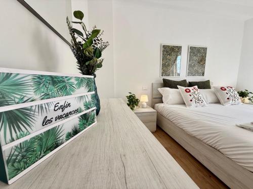 Un dormitorio con una cama y una planta en la pared. en Suite dei Principi 3, aeroporto e parcheggio gratuito, en Bari