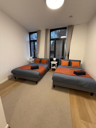 ブリュッセルにあるAppartment Wayez 3の窓が2つある部屋にベッドが2つある