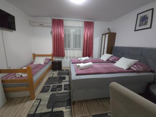 a bedroom with two beds and a couch at Guest House Nana in Mostar