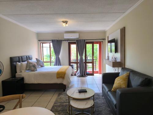 een woonkamer met een bed en een bank bij Rockmel Apartment in Sandton