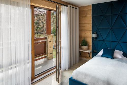 a bedroom with a bed and a sliding glass door at Magdalenka 5 min pieszo od Kotelnicy in Białka Tatrzanska
