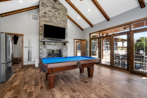 a pool table in a living room with a fireplace at Calaboose Retreat in Campton