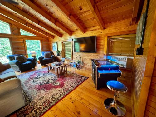a living room with a couch and a tv at Hot Tub & WiFi - Big Boulder - Red River Gorge KY in Rogers
