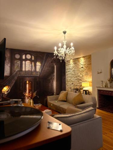 a living room with a couch and a chandelier at L'Idéal - charme de l'ancien et modernité - Hyper Centre in Vannes