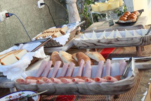 a table with several trays of hot dogs and bread at Hotel Tikary in Arequipa