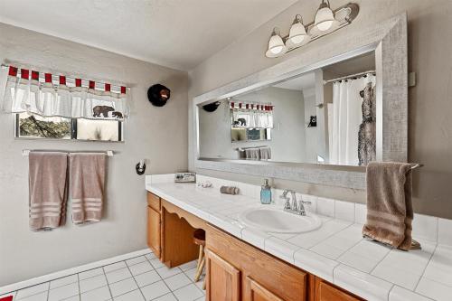 ein Badezimmer mit Waschbecken und Spiegel in der Unterkunft Amazing Views Central AC 5 ac of Privacy Lawn Games and HOT TUB in Elden Pueblo