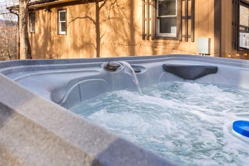 a hot tub with a water fountain in it at River Access Cabin with Hot Tub, Fire Pit, & WiFi! in Morton Grove