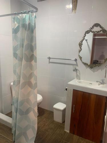 a bathroom with a sink and a toilet and a mirror at Shakai suite in Tena