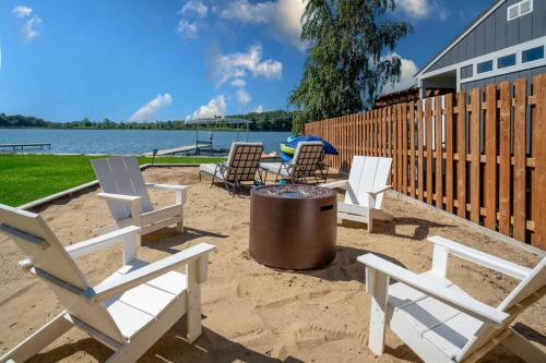 un groupe de chaises et une poubelle sur une plage dans l'établissement The Lake House on Myers Bay - 3-Bed 2-Bath Luxury Home with Private Pier Beach Firepit and Deck, à Fox Lake
