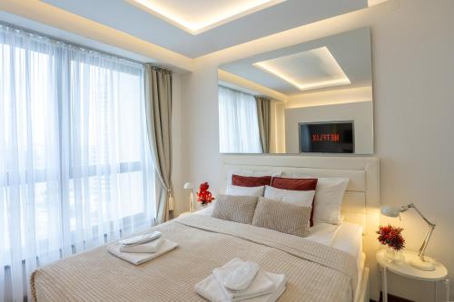 Un dormitorio blanco con una cama grande y una ventana. en Bw Zuma Apartments, en Belgrado