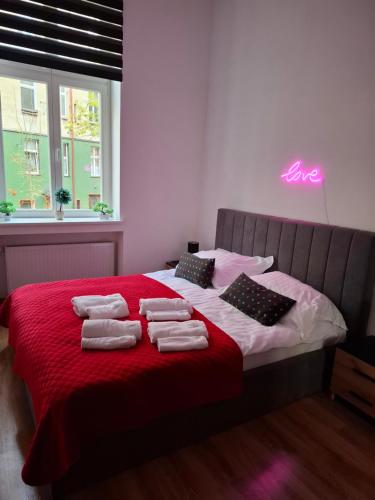 a bedroom with a bed with towels on it at Apartament Love on 5 - Miłość na 5 in Legnica