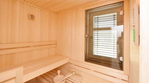 a room with a sauna with a window at Exklusive Reetdach-Villa Ostseefrische in Lobbe