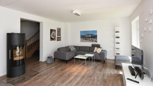 ein Wohnzimmer mit einem Sofa und einem Kamin in der Unterkunft Exklusive Reetdach-Villa Ostseefrische in Lobbe