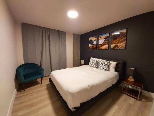 ein Schlafzimmer mit einem Bett und einem blauen Stuhl in der Unterkunft Corporate Stays La Vigie 2 - 1 Bedroom in Québec