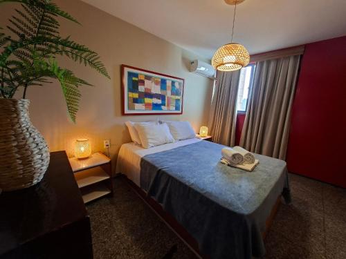 a bedroom with a bed and a potted plant at Flat Atlântico Meireles by Escala in Fortaleza