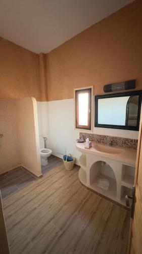 a bathroom with a sink and a toilet in a room at Riad Azwaw in Er Rachidia