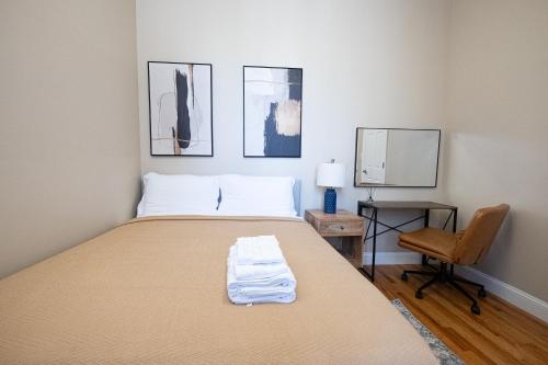 a bedroom with a bed and a chair and pictures at Sunlit 2BR Central Park North elevator & laundry in New York