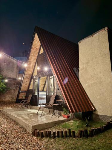 a house with a red roof with chairs outside at night at Cantinho do Vale# in Pomerode