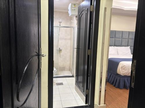 a bathroom with a shower and a bedroom with a bed at Swiss Blue serviced Apartments- Al Zahra in Jeddah