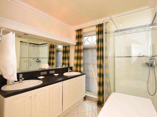 a bathroom with two sinks and a shower at Ferienwohnung Parkblick in Poseritz