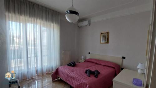 a bedroom with a red bed and a large window at A Casa di Nonna Lidia in Crotone