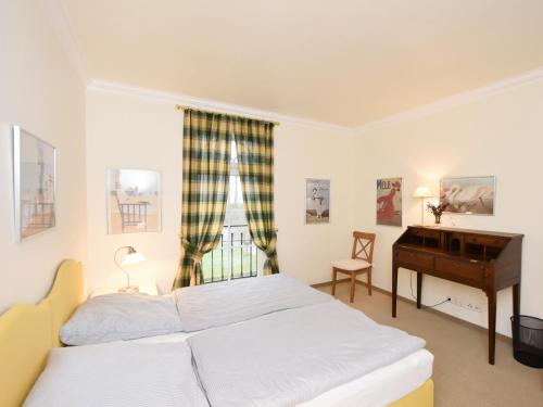 a bedroom with a bed and a desk and a window at Ferienwohnung Parkblick in Poseritz