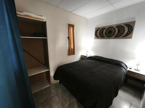 una camera con letto in una stanza con mensola di Posada 25 a San Rafael