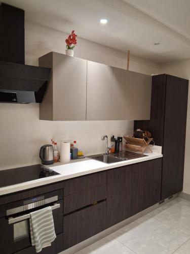 una cucina con mobili marroni e un lavandino di Mirage suite a Accra