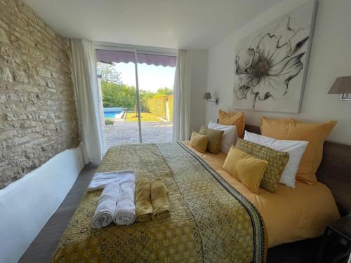 a bedroom with a large bed with towels on it at Le Mas de Laché in Caylus