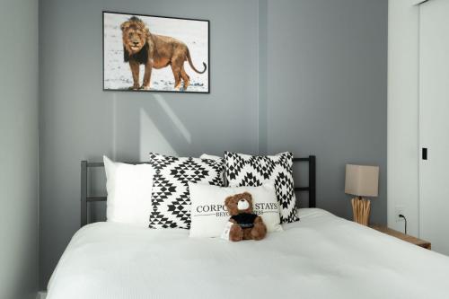 ein Teddybär, der auf einem Bett sitzt in der Unterkunft The Lennox Pet Friently 2 Bedroom Rental in Ottawa 613 in Ottawa