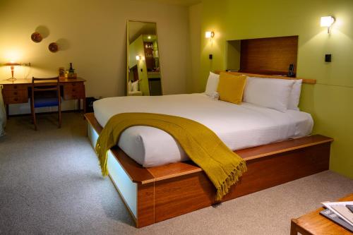 a bedroom with a large bed with a blanket on it at Ohtel Wellington in Wellington