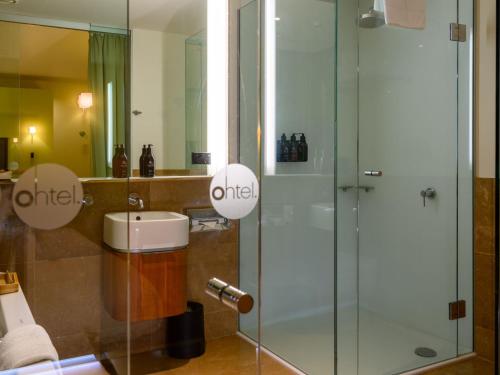 a bathroom with a glass shower and a sink at Ohtel Wellington in Wellington