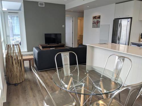 ein Wohnzimmer mit einem Glastisch und einer Couch in der Unterkunft Calgary 2 Bedrooms Apartment in Calgary