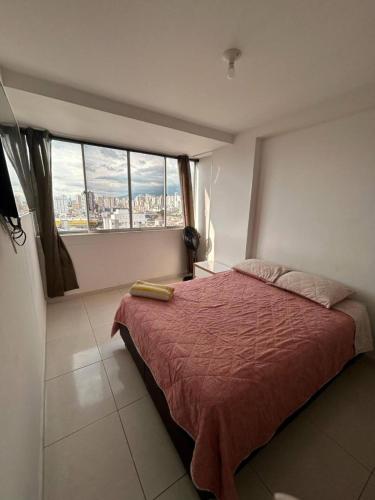 a bedroom with a bed and a large window at Apto de 1 Habitación - Vista, Frescura, Buen Ambiente y cerca de todo in Bucaramanga
