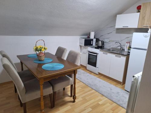 a kitchen with a table and chairs and a kitchen with a refrigerator at VISOKO Room in Visoko