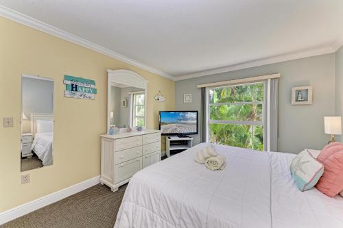 a bedroom with a white bed and a television at Beach Castle #18 in Longboat Key