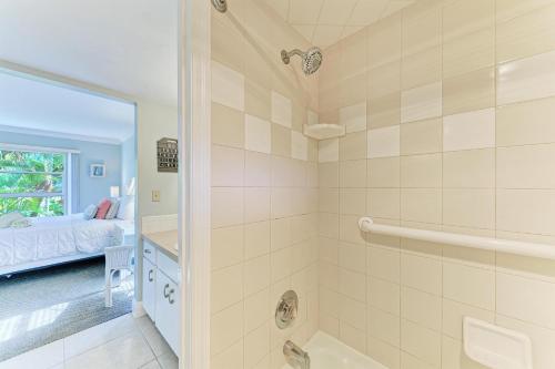 a bathroom with a walk in shower and a bed at Beach Castle #18 in Longboat Key