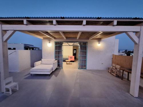 a pergola with a white couch on a patio at מעיינות האהבה in Reshafim