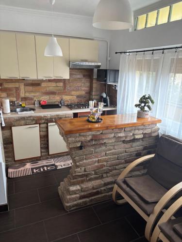 eine Küche mit einer Steintheke und einem Stuhl darauf in der Unterkunft Zenora Apartman in Makó