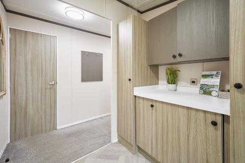 a kitchen with wooden cabinets and a white counter top at Happy Days Lodge with Hot Tub in York