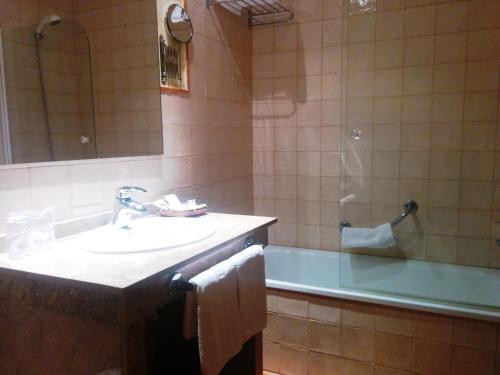 W łazience znajduje się umywalka, wanna i umywalka. w obiekcie Hotel Sierra de Andujar w mieście Virgen de la Cabeza