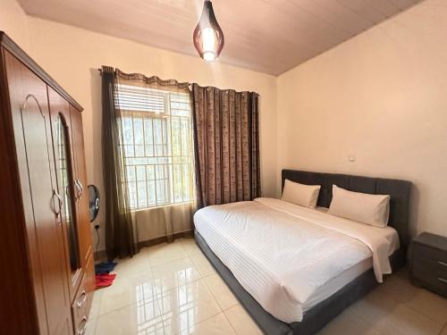 ein Schlafzimmer mit einem Bett und einem Fenster in der Unterkunft EASY KIGALI STAY Apartment in Kigali