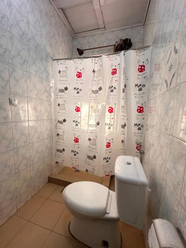 ein Badezimmer mit Toilette und Duschvorhang in der Unterkunft EASY KIGALI STAY Apartment in Kigali