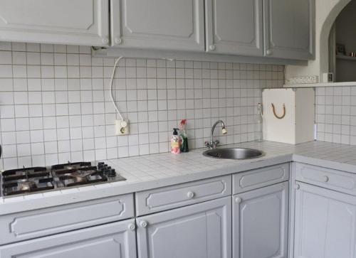 a kitchen with white cabinets and a sink and a stove at aranjata modern o camera in Cugir in Cugir