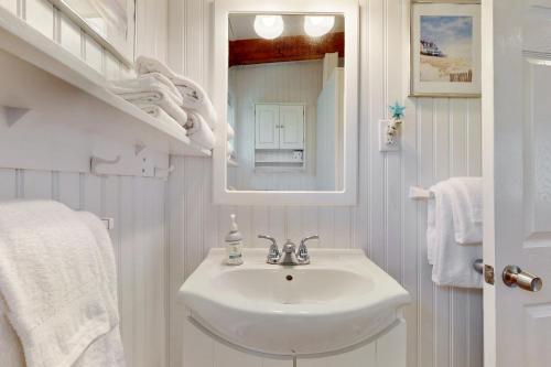 a white bathroom with a sink and a mirror at Sparkling Sands Holiday House M2 in Moody