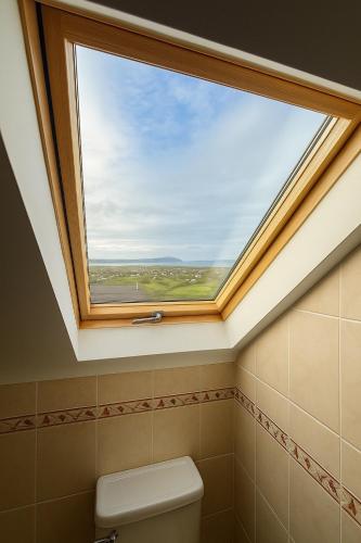 a skylight in a bathroom with a toilet and a window at 4 Bedroom House By Travel Lets Holiday Homes Carrigart With Sea View in Carrigart