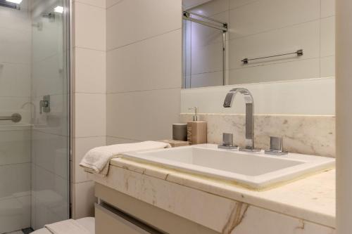 a white bathroom with a sink and a shower at Flat à beira-mar Solar Tambaú - MyFlats in Tambaú